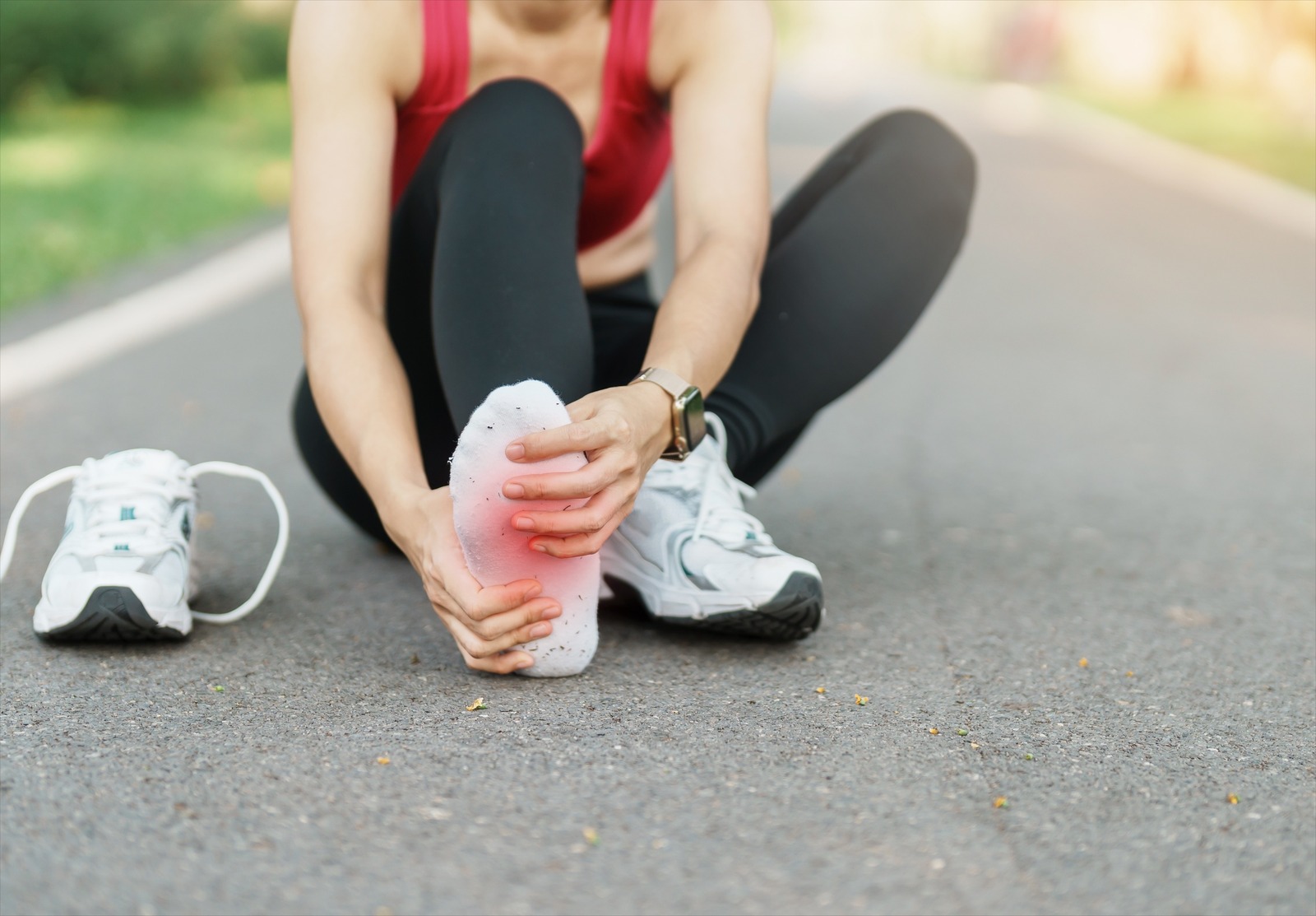 Runner holding their foot, suffering from arch pain.