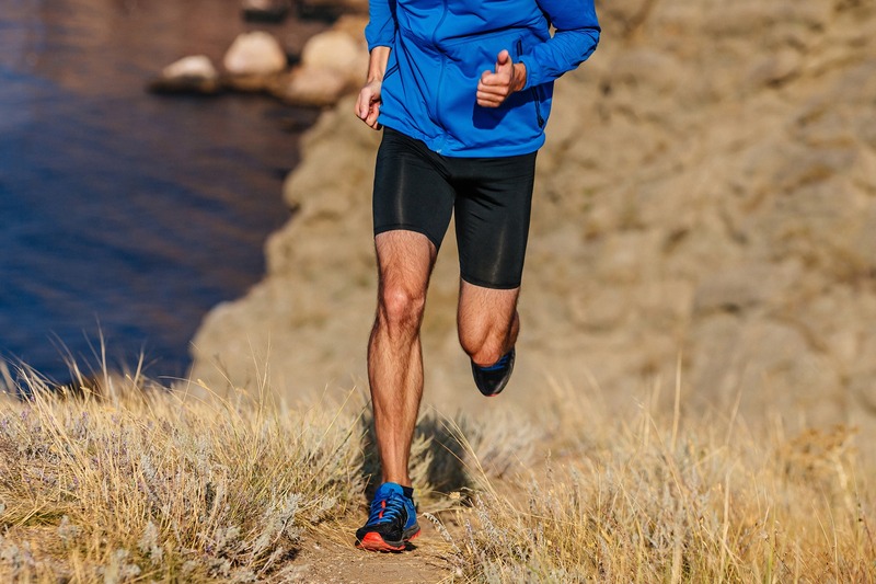 Man running up a grassy hill.