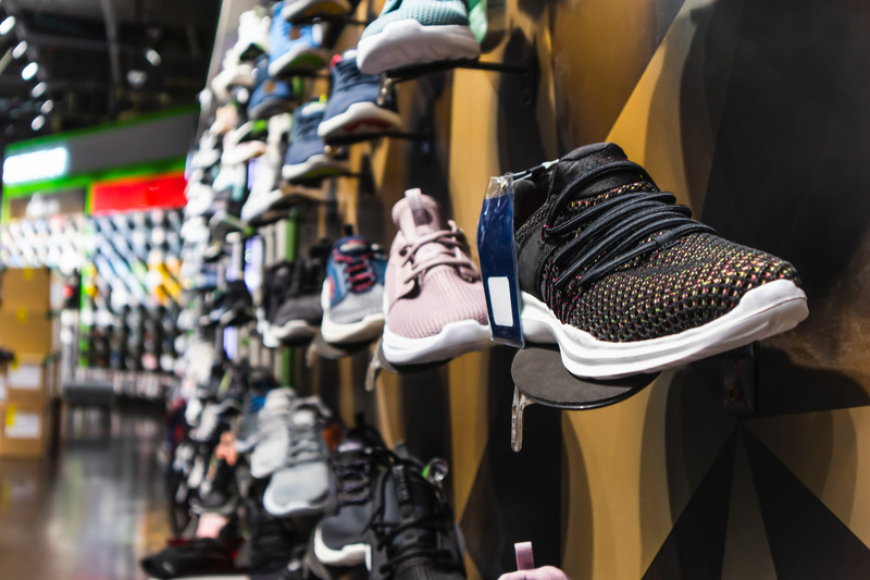 Wall of running shoes on display at a store.